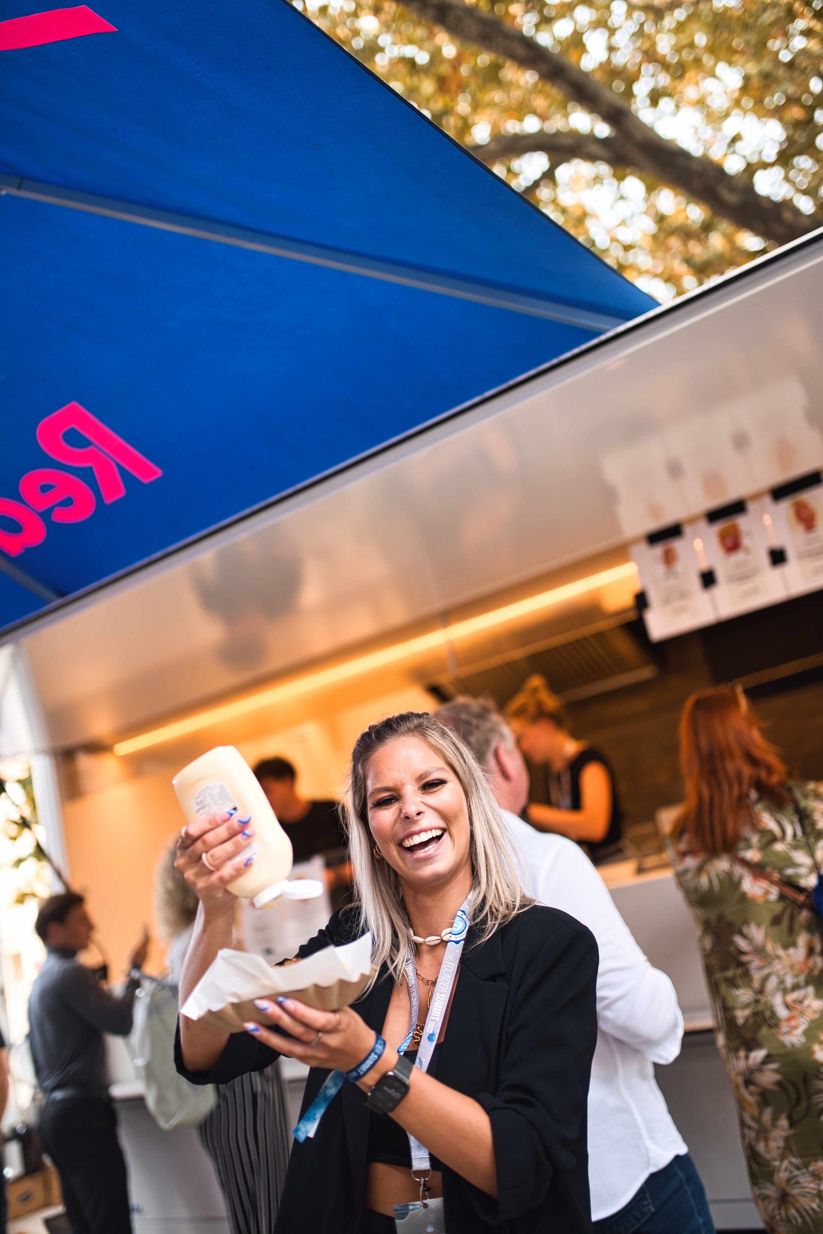 Frau isst HotDog vor einem Foodtruck einer Business-Veranstaltung in Wiesbaden